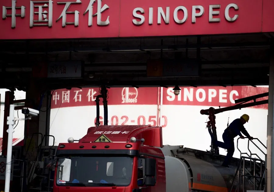 This file photo taken on 22 March 2018 shows a man working in a filling station of Sinopec, China Petroleum and Chemical Corporation, in Shanghai. Five major Chinese companies including two of the country's largest oil producers will delist from the New York Stock Exchange, the firms said in filings on 12 August 2022. (Johannes EISELE/AFP)