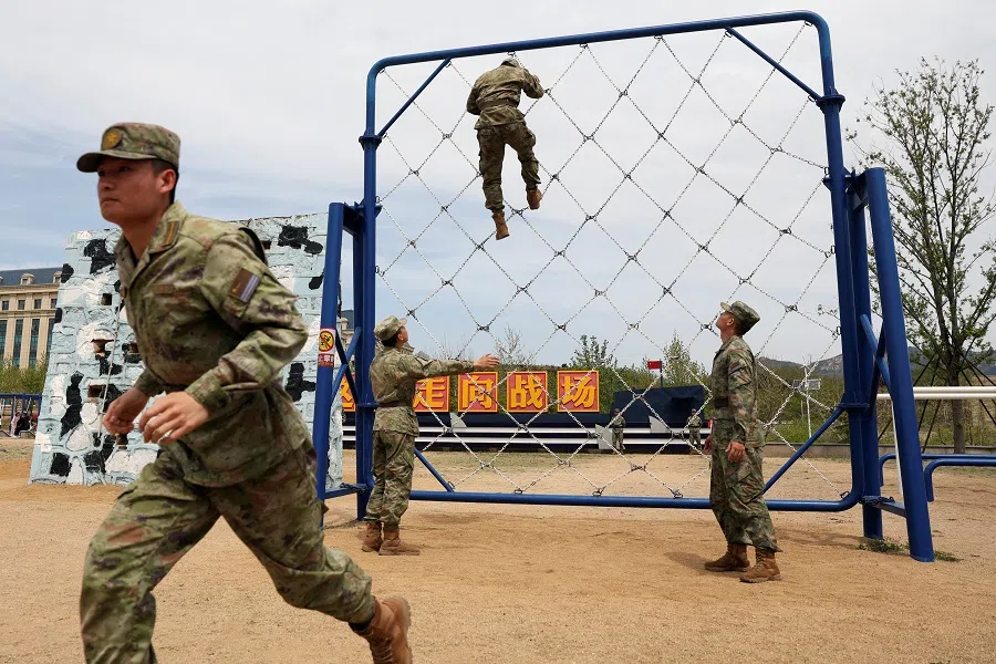 Cadets demonstrate a training session on an obstacle course during a media tour to an open day at the PLA Naval Submarine Academy, ahead of the 75th founding anniversary of the PLAN, in Qingdao, Shandong province, China, 21 April 2024. (Florence Lo/Reuters)