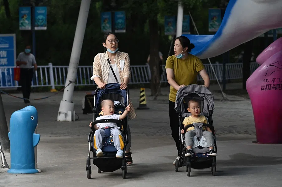 Two women push children in prams outside a zoo in Beijing, China, on 9 September 2021. (Greg Baker/AFP)