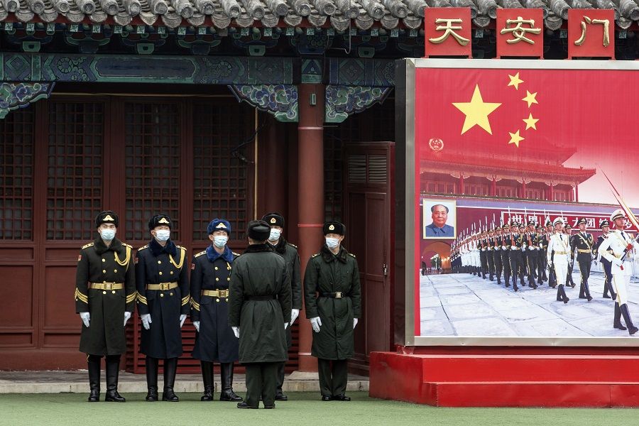 Members of the People's Liberation Army (PLA) honour guard stand next to a banner near the Forbidden City in Beijing, China, on 3 March 2021 ahead of the National People's Congress that opens on 5 March. (Qilai Shen/Bloomberg)