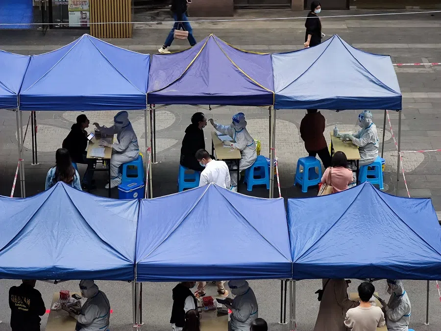 Medical workers take swap samples from residents for Covid-19 at a testing site in Chongqing, China, 3 November 2022. (China Daily via Reuters)