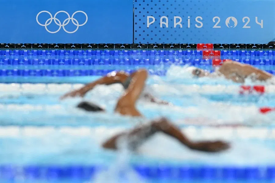 A photo shows the event logo and Olympic rings as swimmers compete in a heat of the men’s 400m freestyle swimming event at the Paris 2024 Olympic Games at the Paris La Defense Arena in Nanterre, Paris, France, on 27 July 2024. (Jonathan Nackstrand/AFP)