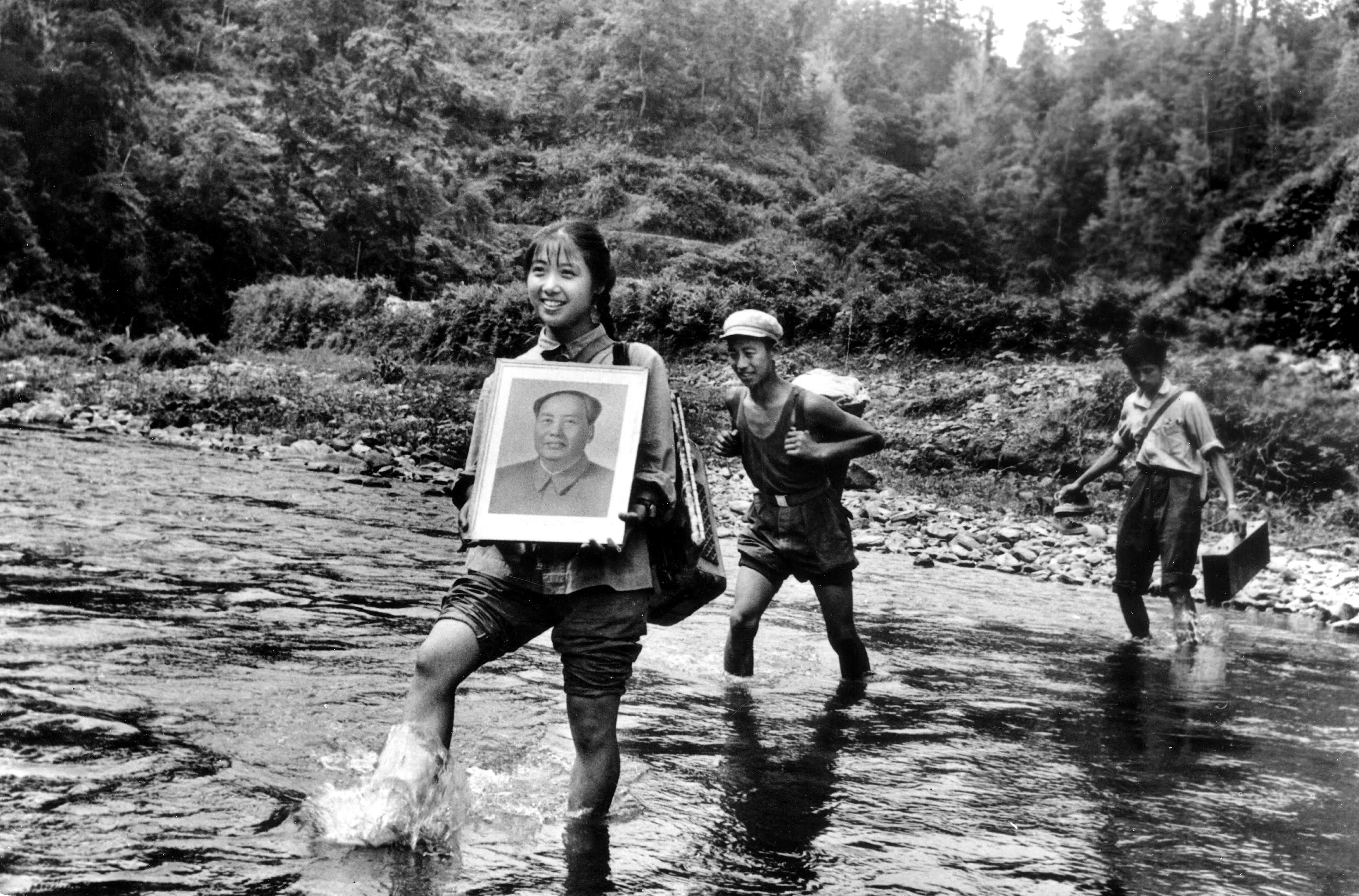 A young woman from Shanghai sent down to the countryside holds Mao’s portrait, 1968.