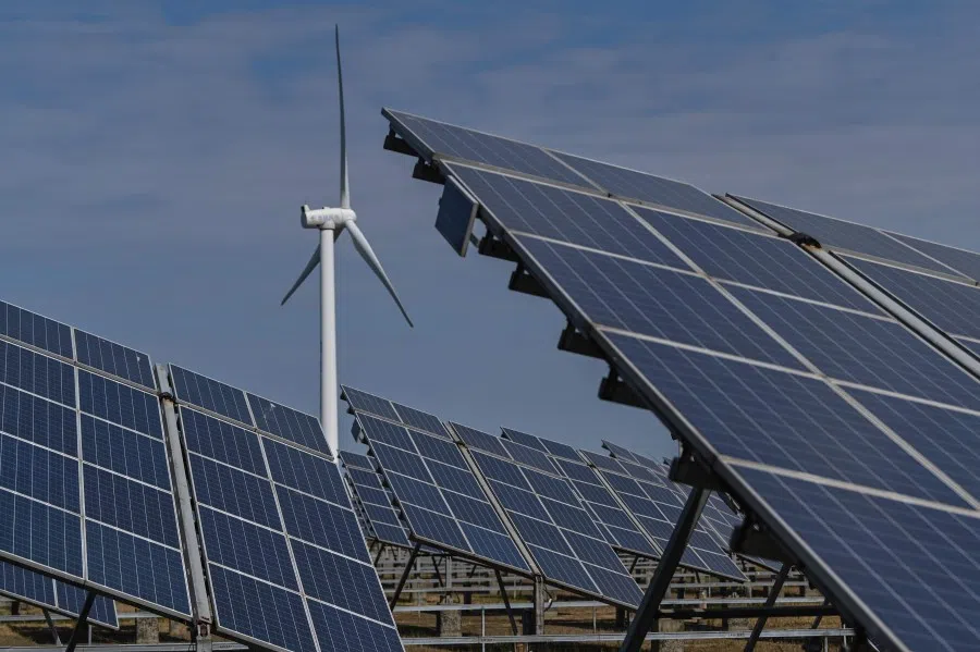 Solar panels and a wind generator are seen at an integrated power station in Yancheng city, in Jiangsu province, China, on 14 October 2020, during a media tour organised by the local government. (Hector Retamal/AFP)