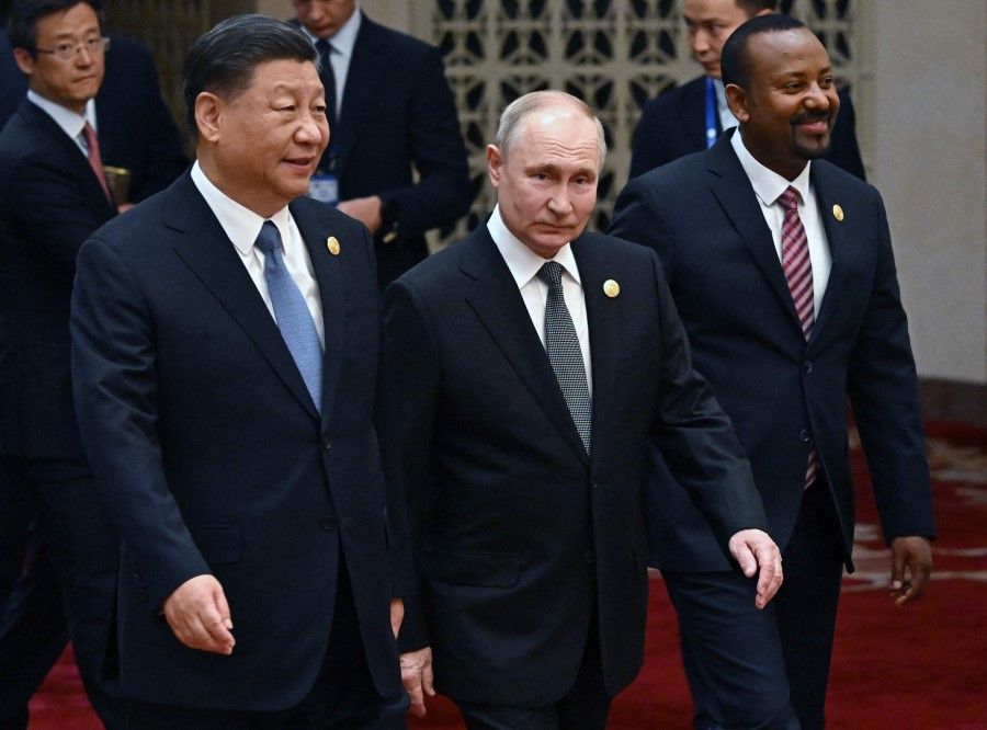 This pool photograph distributed by Russian state owned agency Sputnik shows Russia's President Vladimir Putin and Chinese President Xi Jinping heading to a group photo session during the third Belt and Road Forum for International Cooperation at the Great Hall of the People in Beijing on 18 October 2023. (Grigory Sysoyev/Sputnik/AFP)