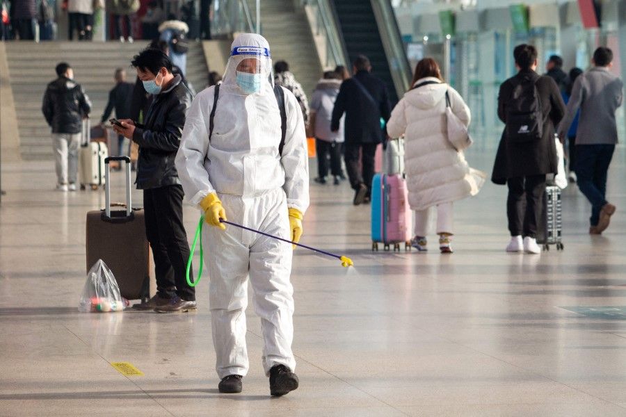 This photo taken on 16 January 2022 shows a staff member spraying disinfectant in preparation for the upcoming Lunar New Year travel peak at the Nanjing railway station in China's eastern Jiangsu province. (AFP)