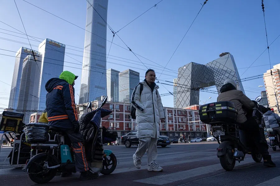 People walk on a street in Beijing, China, on 30 December 2024. (Na Bian/Bloomberg)