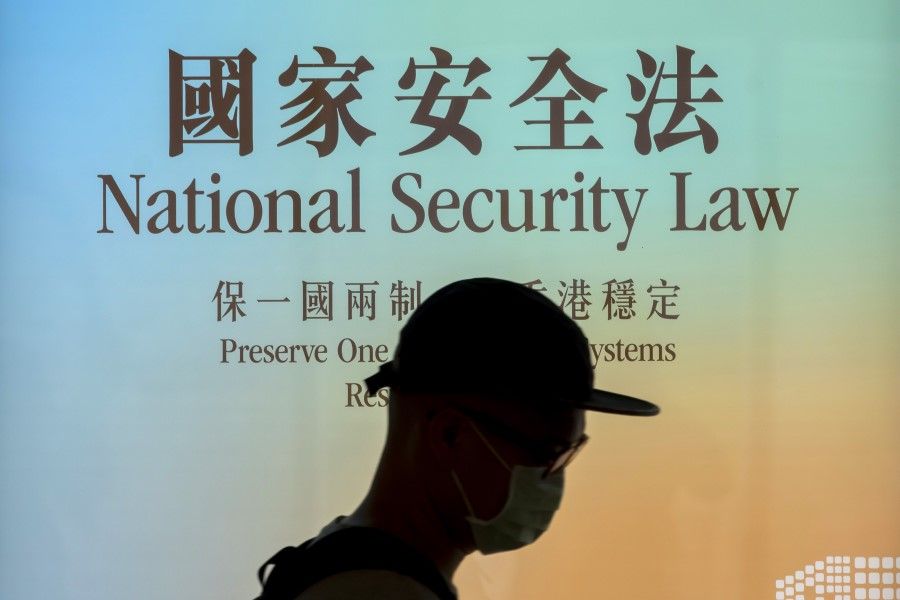 A pedestrian walks past a government-sponsored advertisement promoting a new national security law in Hong Kong, 29 June 2020. (Paul Yeung/Bloomberg)