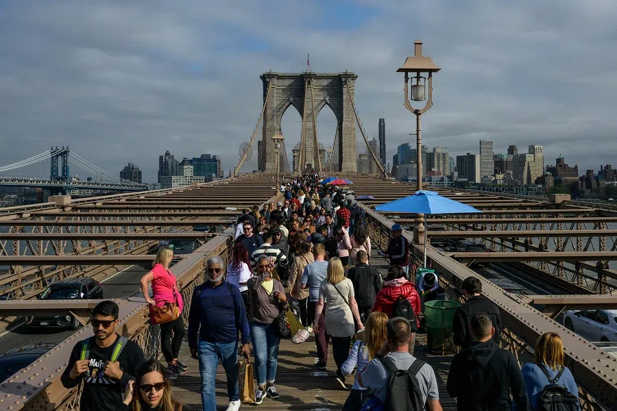 People make their way over the Brooklyn Bridge in New York City, US, on 21 April 2023. (Angela Weiss/AFP)