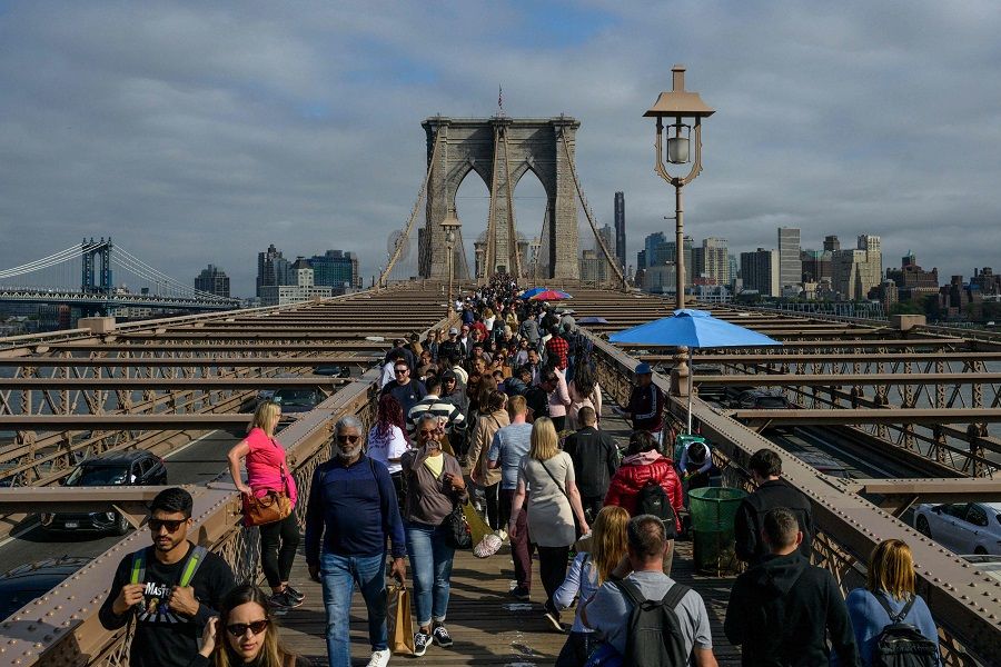 People make their way over the Brooklyn Bridge in New York City, US, on 21 April 2023. (Angela Weiss/AFP)