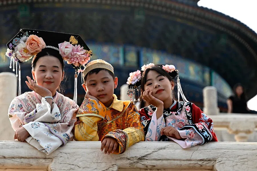 Children wearing traditional costumes posse for a picture at the Temple of Heaven in Beijing on 3 July 2024. (Pedro Pardo/AFP)