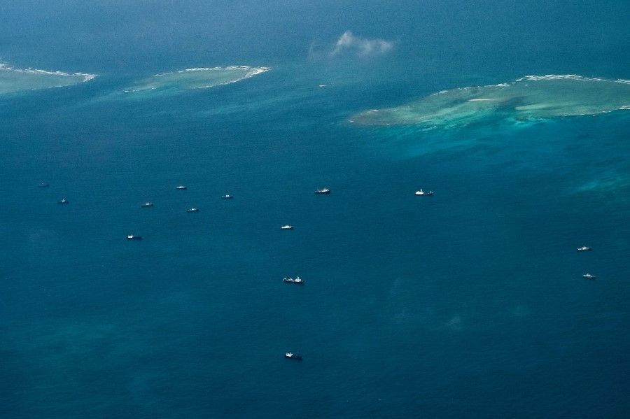 An aerial view taken on 9 March 2023 shows vessels identified by the Philippine Coast Guard as Chinese maritime militia vessels near Thitu Island in the South China Sea. (Jam Sta Rosa/AFP)