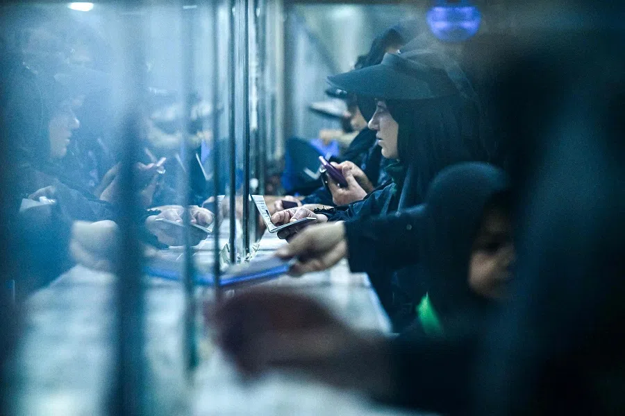 Iranian Muslim pilgrims crossing into southern Iraq through the Shalamjah border crossing present their travel documents at border control on 13 August 2024 as they arrive ahead of the Arbaeen commemorations that mark the end of the 40-day mourning period for the seventh century killing of the Prophet Mohamed’s grandson Imam Hussein ibn Ali. (Hussein Faleh/AFP)