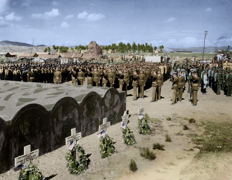 Eight soldiers fire their guns in salute at the funeral of fallen 14th Air Force pilots, including a Jew, with local residents participating, 1944. The graves were designed to be easy to access, so that the remains could be sent back after the war.