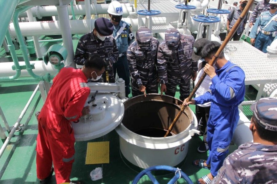 Indonesian Navy personnel inspect a tank of the Panamanian-flagged tanker, the MT. Zodiac Star, that was seized on suspicion of conducting illegal activities in the country's waters and carrying more than 4,000 tons of oil without valid permits, in the waters off Batam, Riau islands, Indonesia, 1 September 2021. (Indonesian Navy/Handout via Reuters)
