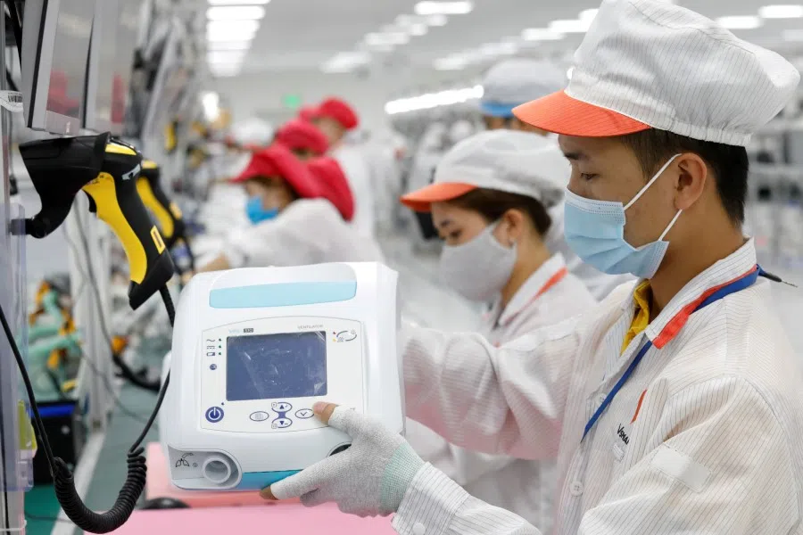 Workers on an assembly line to produce ventilators amid the spread of the coronavirus at a factory outside Hanoi, Vietnam, 3 August 2020. (Kham/REUTERS)