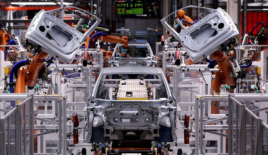 In this file photo taken on 25 February 2020, robotic arms mount doors to a model of the ID.3 Volkswagen electric car at an assembly line of the car factory of German car maker Volkswagen in Zwickau, Germany. (Ronny Hartmann/AFP)
