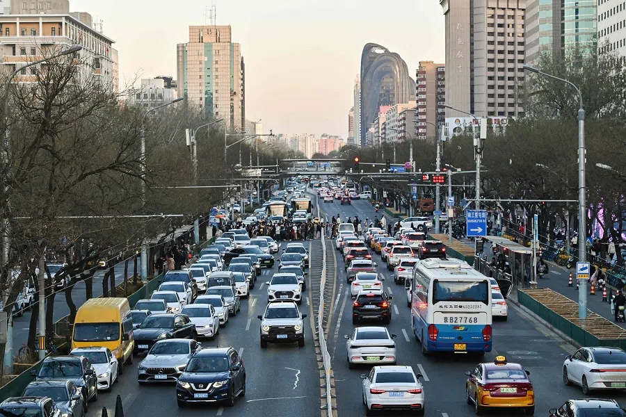 Motorists drive their cars along a road at the Sanlitun business area in Beijing on 30 November 2024. (Adek Berry/AFP)