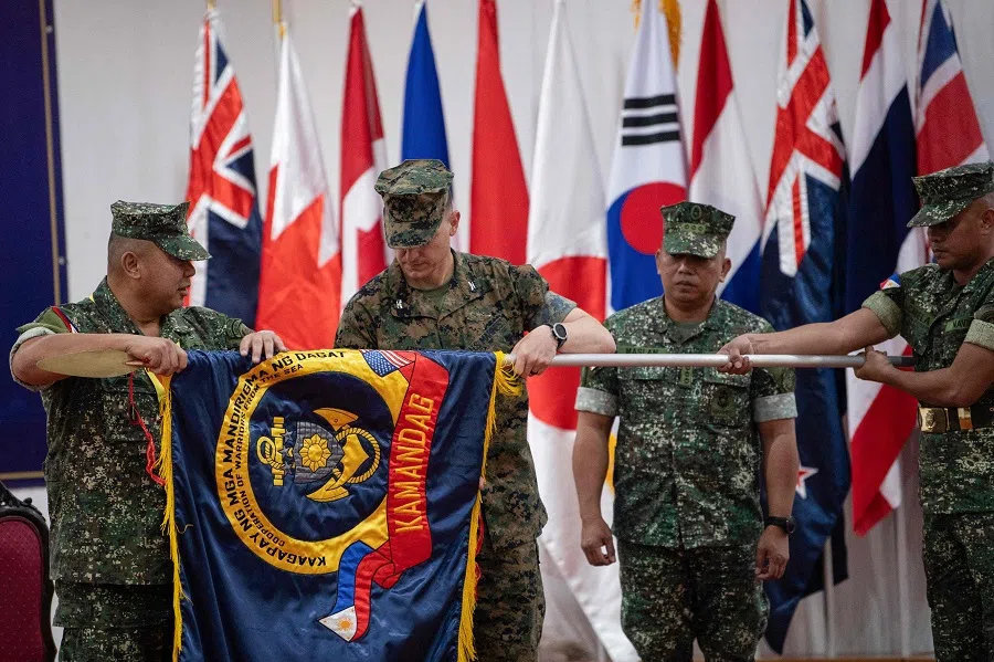Philippine marines Commandant Major General Arturo Rojas (left), and US marines Colonel Jason Armas (second from left) commanding officer marine rotational force-Darwin 25.3, unfurl the exercise flag during the opening ceremony of the “Kamandag” annual military exercise between the US and Philippines in Manila on 26 May 2025.
