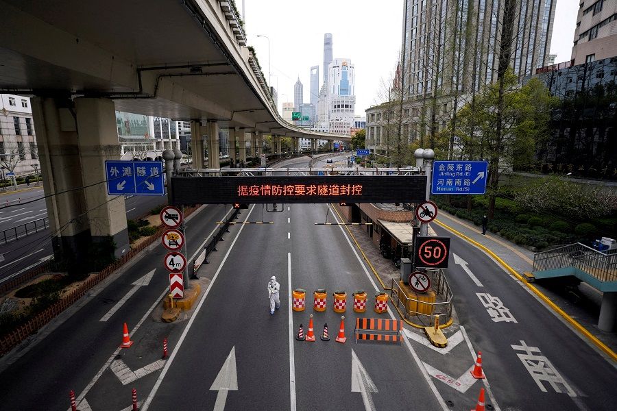 A worker in a protective suit walks at an entrance to a tunnel leading to the Pudong area across the Huangpu river, after restrictions on highway traffic amid the lockdown to contain the spread of the Covid-19 in Shanghai, China, 28 March 2022. (Aly Song/File Photo/Reuters)