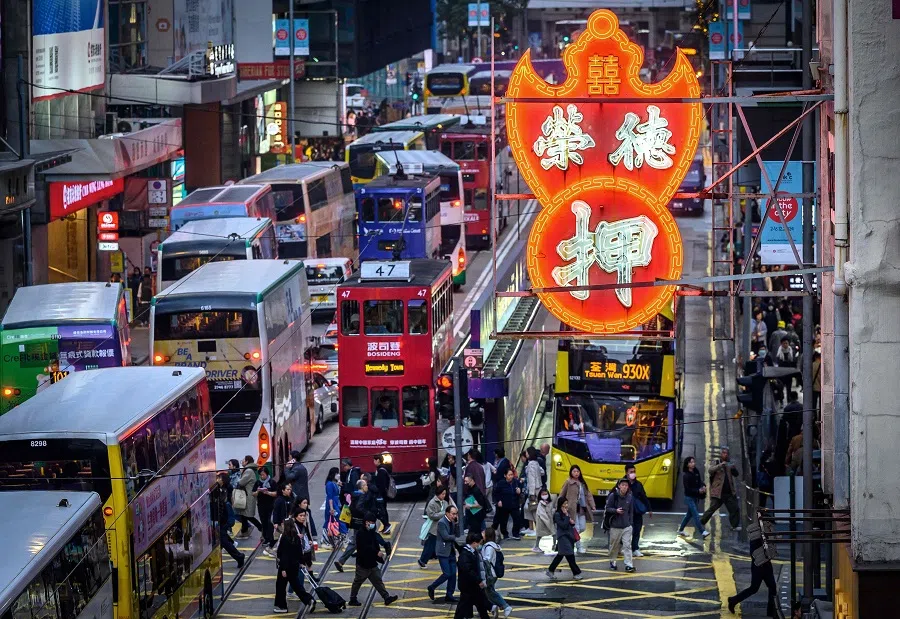 People cross a street during busy evening traffic in Hong Kong on 20 December 2024.