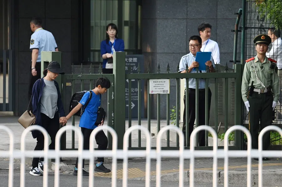 A woman and a boy leave the Japanese embassy in Beijing on 19 September 2024. China on 19 September expressed “regret and sadness” after a Japanese schoolboy who was stabbed in the southern city of Shenzhen died of his injuries. (Greg Baker/AFP)