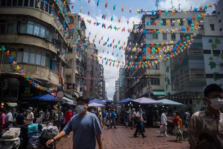 Pedestrians walk on a street in Hong Kong on 31 March 2021. (Anthony Wallace/AFP)