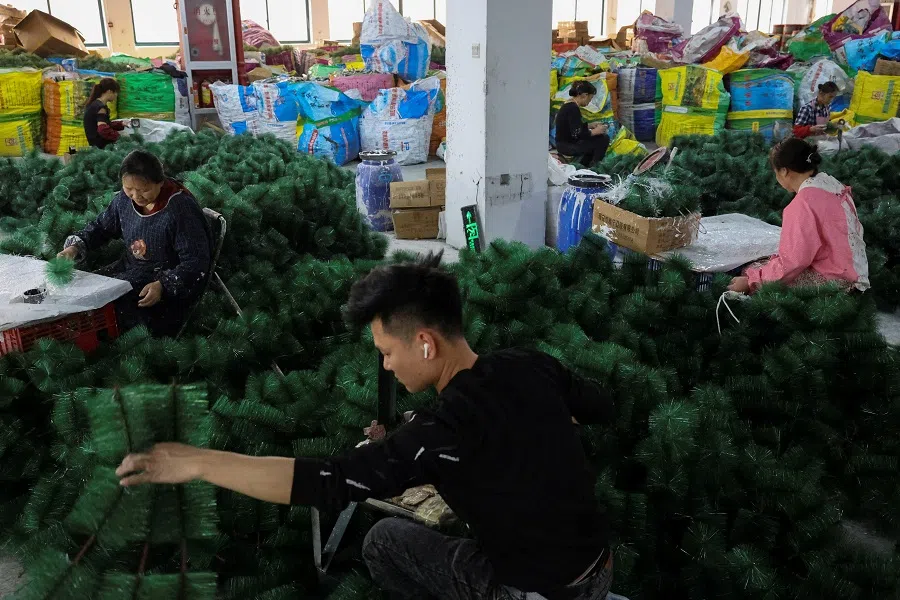 Employees work to produce artificial Christmas trees at a factory in Shaoxing, Zhejiang province, China, on 9 April 2025. (Go Nakamura/Reuters)