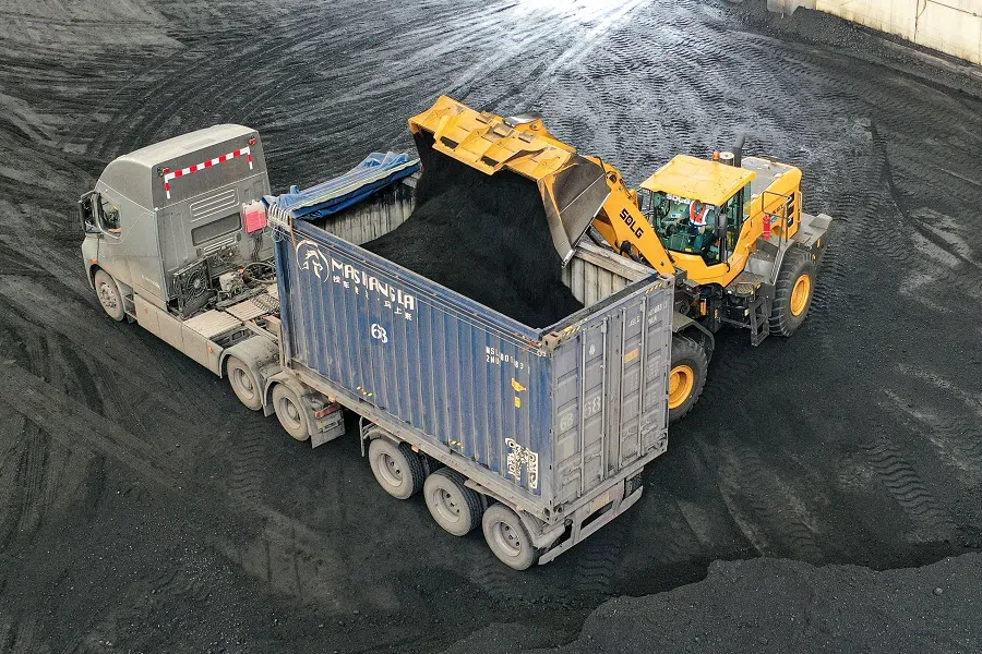 A wheel loader loads coal onto a truck at a coal storage facility of a logistics company in Binzhou, Shandong province, China, on 9 May 2025. (AFP)