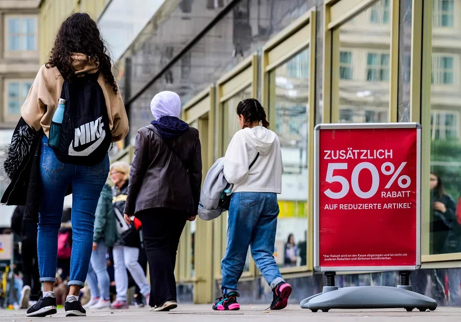 People walk past a clothing retail store in Berlin, Germany, on 29 September 2022. (John Macdougall/AFP)