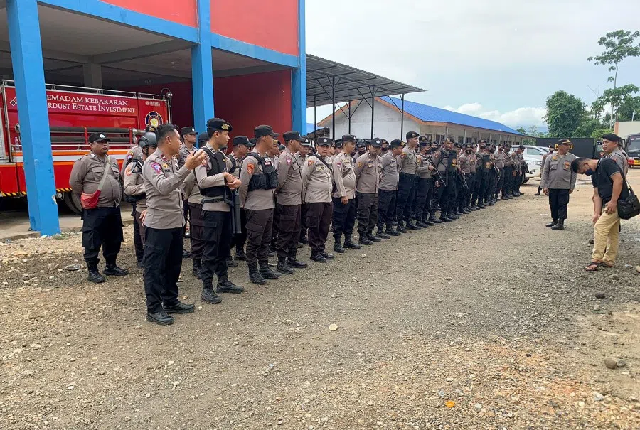 This handout photo taken on 16 January 2023, and released by Morowali Police shows police taking up positions after two workers, including a Chinese national, were killed at a nickel smelting plant in North Morowali, Sulawesi after a riot broke out during a protest over labour conditions. (Handout/Morowali Police/AFP)