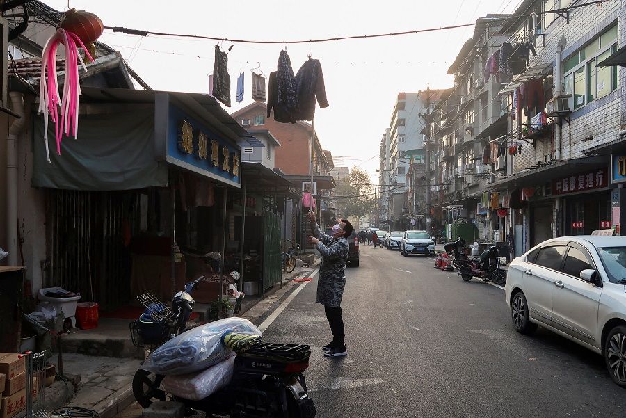 A resident hangs up clothes at a residential neighbourhood, after the government eased Covid-19 restrictions, in Wuhan, Hubei province, China, 10 December 2022. (Martin Pollard/Reuters)