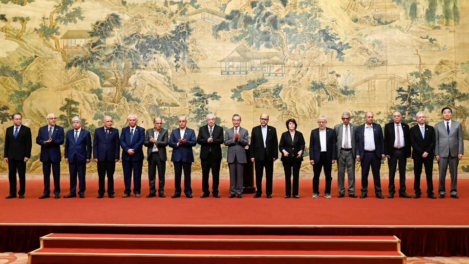China’s Foreign Minister Wang Yi poses for a group picture with members of the Palestinian factions during the signing of the “Beijing Declaration” at the Diaoyutai State Guesthouse in Beijing on 23 July 2024. (Pedro Pardo/Reuters)
