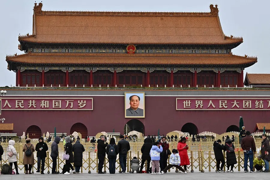 People gather in Tiananmen Square before a portrait of late communist leader Mao Zedong at Tiananmen Gate in Beijing on 3 March 2025. (Pedro Pardo/AFP)