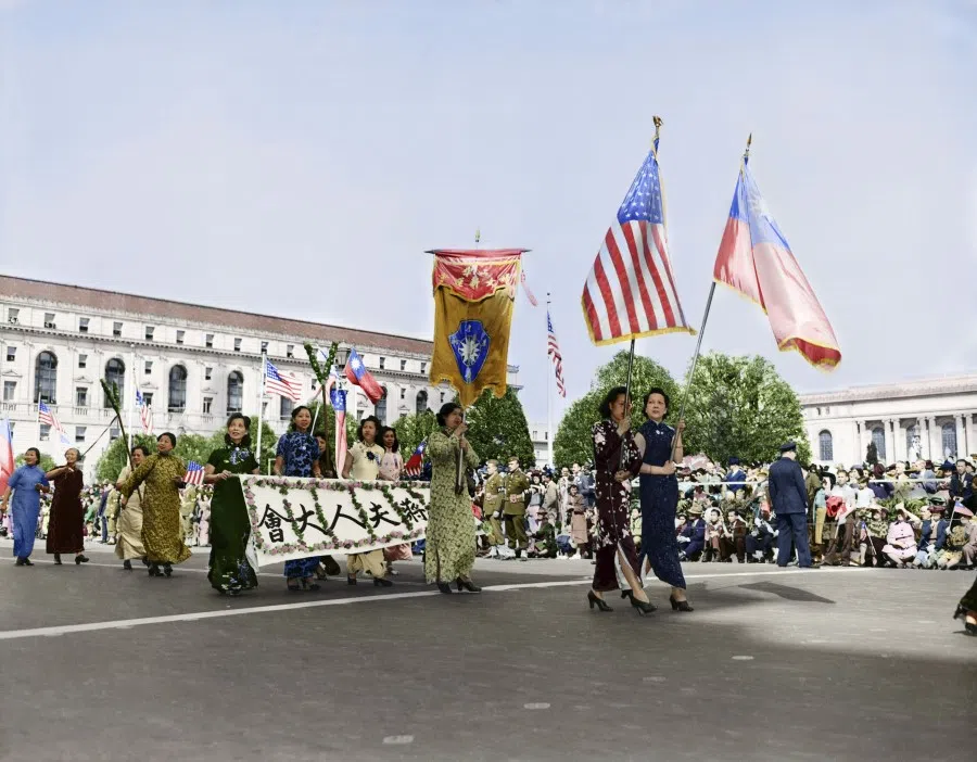 Women in the Chinese community in San Francisco wearing traditional qipao and waving the US and Republic of China flags to welcome Madame Chiang to City Hall, 25 March 1943.
