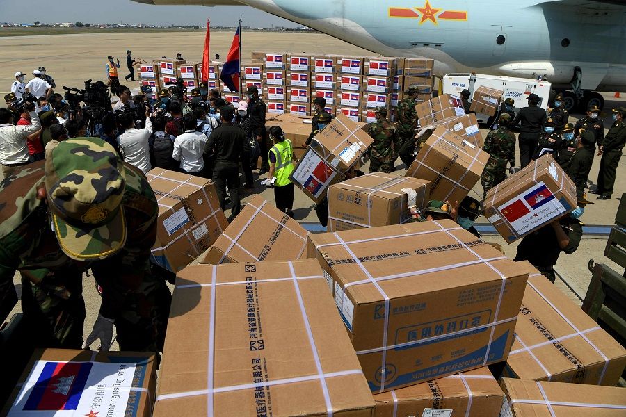 Cambodian soldiers carry aid including medical equipment from China, to be used to combat the spread of the Covid-19 coronavirus, at Phnom Penh International Airport in Phnom Penh on 25 April 2020. (Tang Chhin Sothy/AFP)