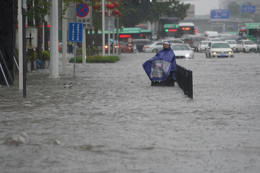 A resident wearing a rain cover stands on a flooded road in Zhengzhou, Henan province, China, 20 July 2021. (CNS photo via Reuters)