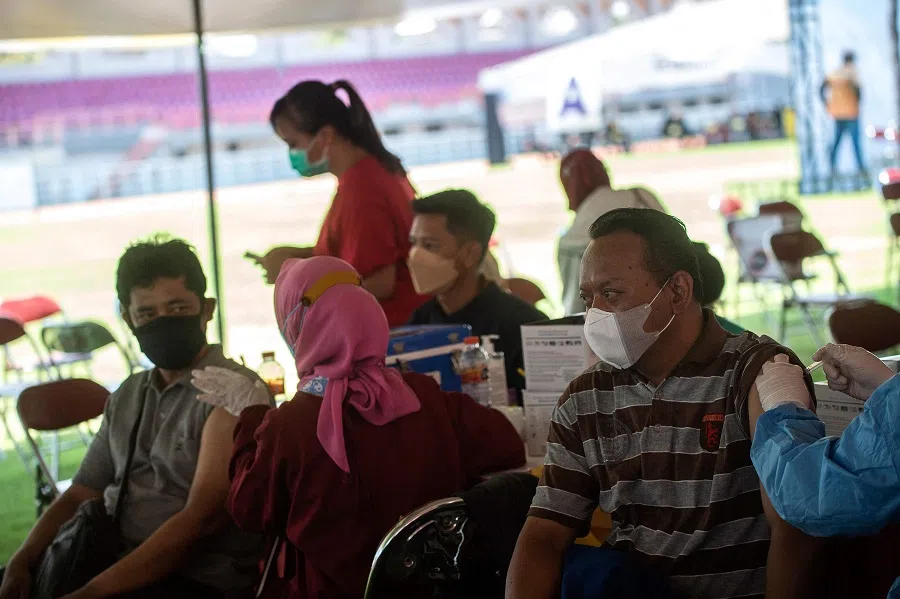 Residents receive the Sinovac Covid-19 coronavirus vaccine at a makeshift mass vaccination centre on a football field in Surabaya, Indonesia, on 30 September 2021. (Juni Kriswanto/AFP)
