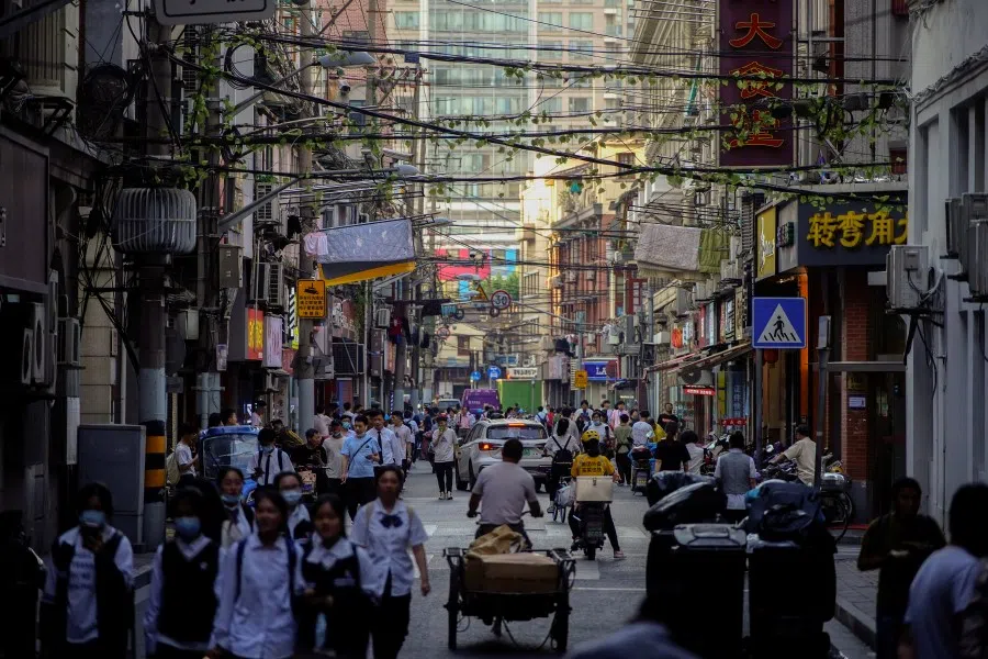 People walking on a street in Shanghai, China on 10 May 2021. (Aly Song/Reuters)