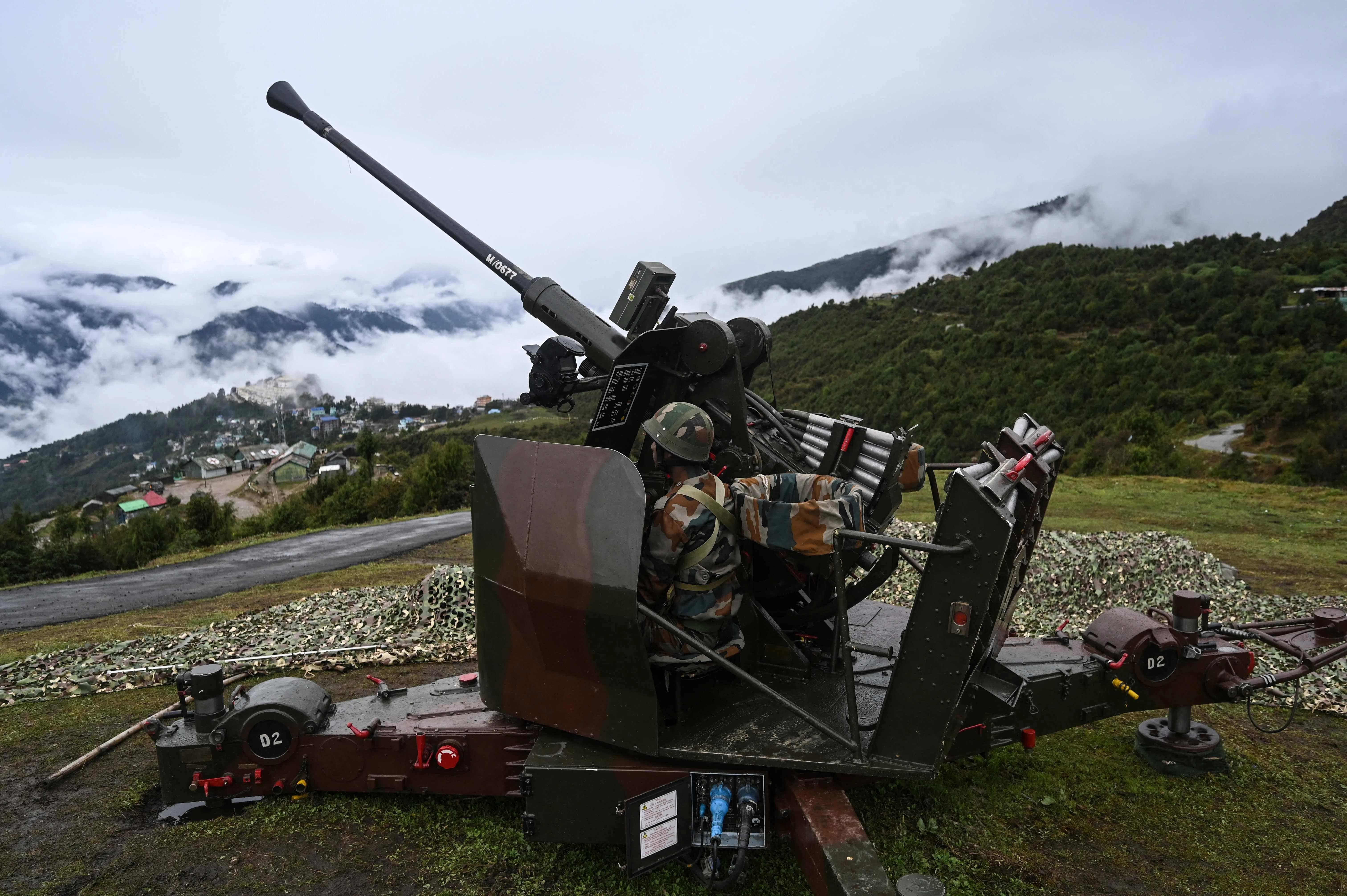 An Indian Army soldier sits inside an upgraded L70 anti aircraft gun in Tawang, near the Line of Actual Control (LAC), in the northeast Indian state of Arunachal Pradesh on 20 October 2021.