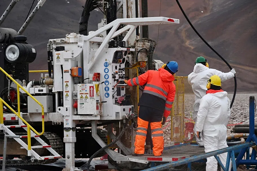 Workers operate a drilling rig at the Aguilar salt flat, located in the Andean mountain range of the Atacama Region, Chile, on 16 May 2024. (Rodrigo Arangua/AFP)