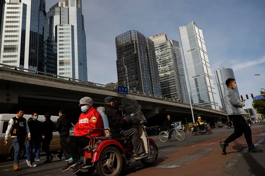 Elderly people cross a street in a tricycle in the Central Business District in Beijing, China, 27 October 2020. (Thomas Peter/Reuters)