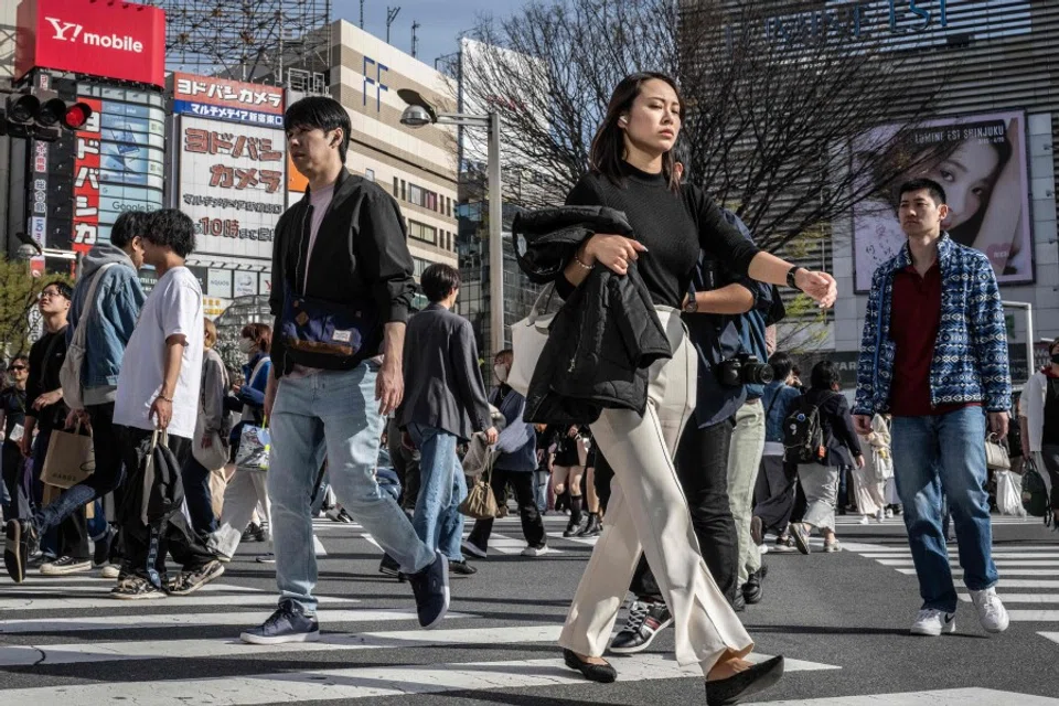 People cross a street in Shinjuku area of Tokyo on 30 March 2024. (Yuichi Yamazaki/AFP)