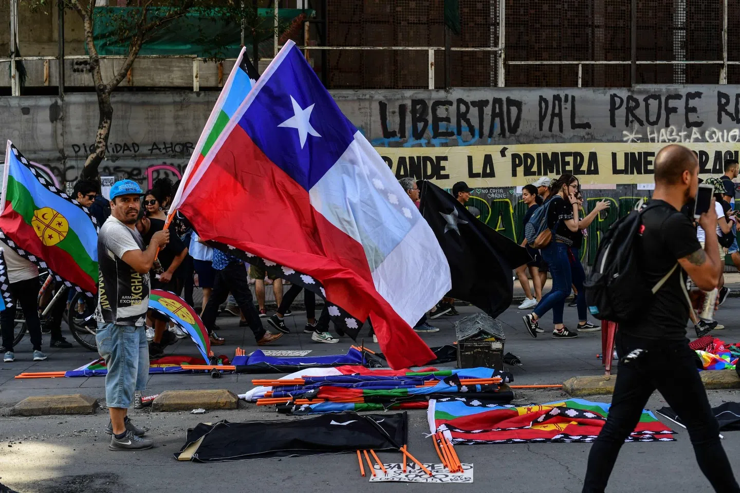 Artists sell merchandise making reference to the social crisis going on in Chile, near Plaza Italia square, site of protests and clashes in Santiago, on November 22, 2019. Since October 18, furious Chileans have been protesting against social and economic inequality, as well as an entrenched political elite that comes from a small number of the wealthiest families in the country, among other issues. (Photo by Martin Bernetti/AFP)