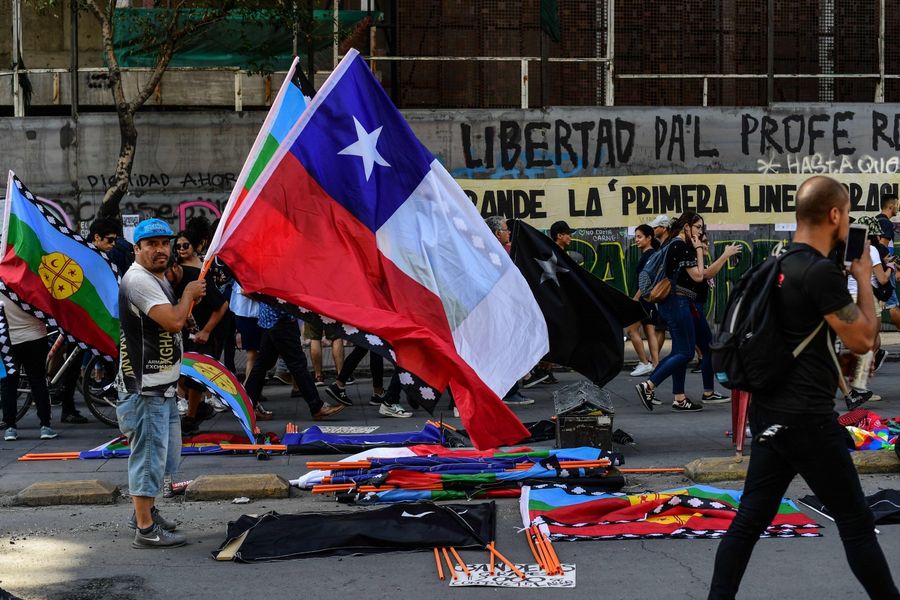 Artists sell merchandise making reference to the social crisis going on in Chile, near Plaza Italia square, site of protests and clashes in Santiago, on November 22, 2019. Since October 18, furious Chileans have been protesting against social and economic inequality, as well as an entrenched political elite that comes from a small number of the wealthiest families in the country, among other issues. (Photo by Martin Bernetti/AFP)