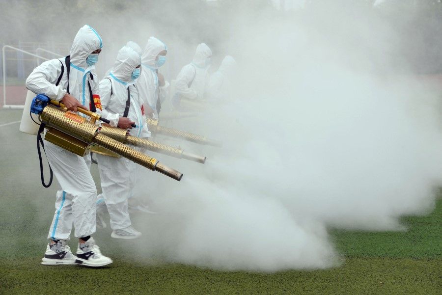 Staff members spray disinfectant at a school ahead of the new semester in Bozhou in China's eastern Anhui province on 23 August 2021. (STR/AFP)