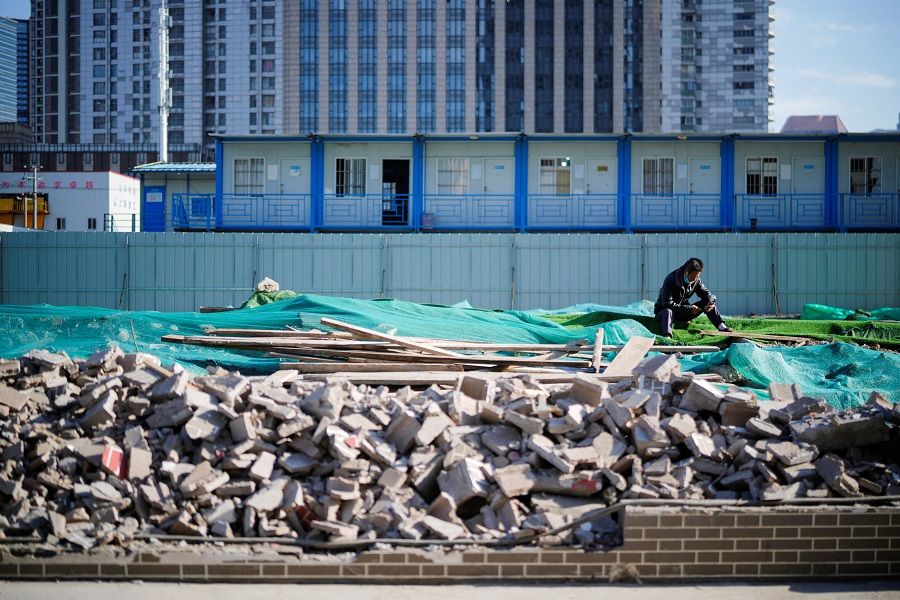 A worker rests on an unfinished road, following the Covid-19 outbreak, in Shanghai, China, 10 October 2022. (Aly Song/Reuters)