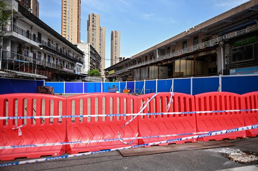 This photo taken on 15 April 2020 shows barriers at the closed Huanan Seafood Market where the Covid-19 coronavirus is believed to have emerged in Wuhan, Hubei, China. (Hector Retamal/AFP)