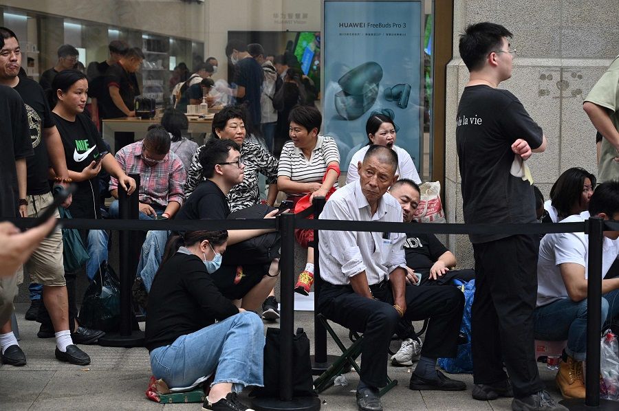 People queue up for hours outside Huawei's flagship store in Shanghai, China on 25 September 2023, hoping to be able to buy the tech giant's latest Mate 60 Pro mobile phone. (Rebecca Bailey/AFP)