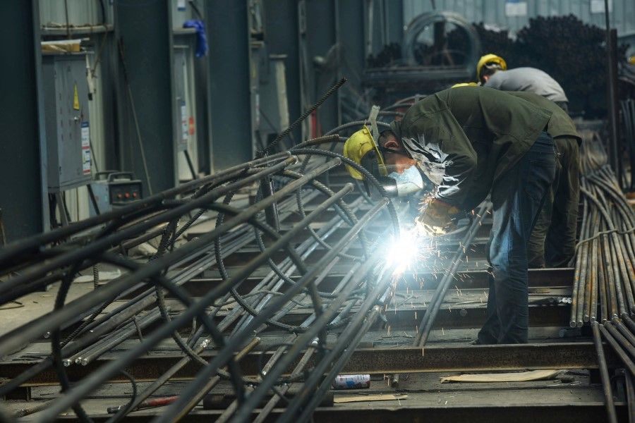 An employee works on steel bars at a factory in Hangzhou, 15 May 2020. (STR/AFP)